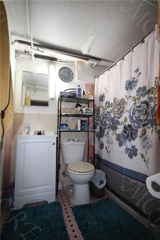 full bathroom with a textured ceiling, a shower with shower curtain, and toilet