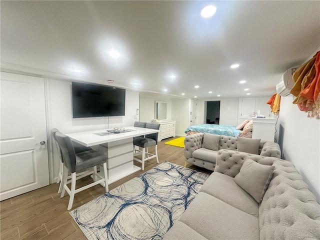 living room featuring an AC wall unit and hardwood / wood-style flooring