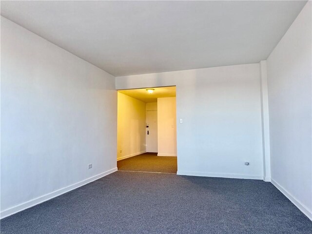 unfurnished room with dark carpet