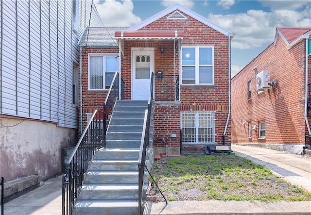 view of front of home featuring ac unit and brick siding