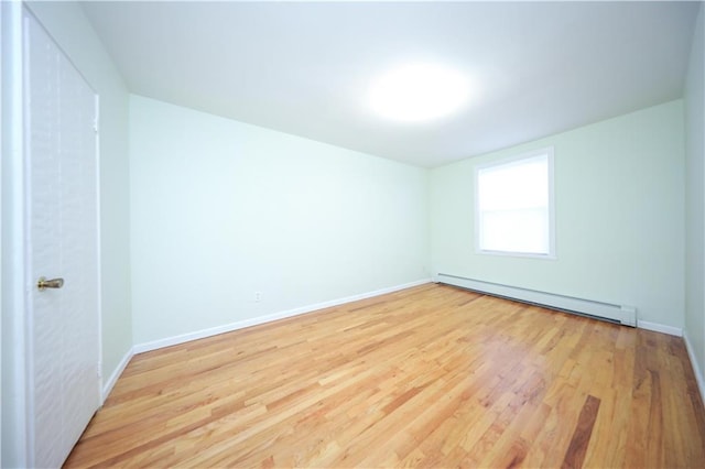 spare room with light wood-type flooring and baseboard heating