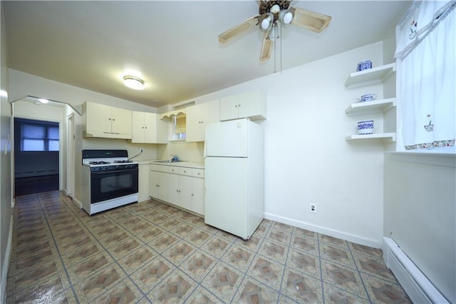 kitchen featuring sink, ceiling fan, a baseboard heating unit, range with gas stovetop, and white fridge