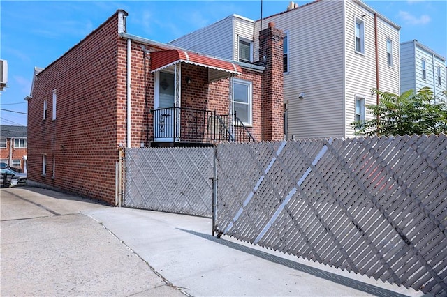 view of side of home with a fenced front yard and brick siding