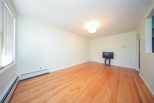 empty room featuring light wood-type flooring and baseboard heating