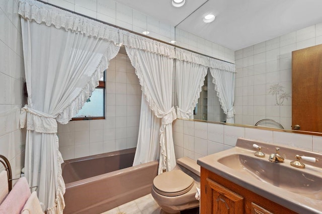 full bathroom featuring shower / tub combo with curtain, toilet, tasteful backsplash, tile walls, and vanity