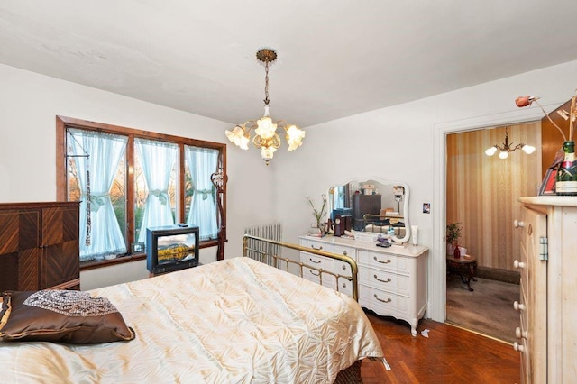 bedroom with an inviting chandelier, dark parquet flooring, and radiator