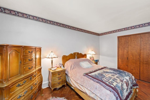 bedroom with dark parquet floors and a closet