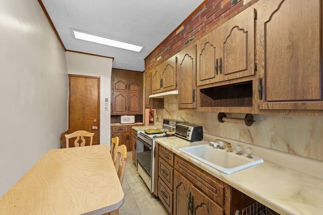 kitchen with brick wall, sink, ornamental molding, light tile patterned floors, and white appliances