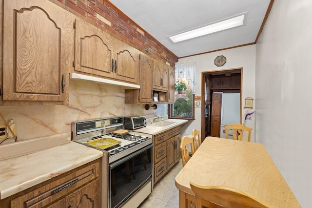 kitchen with sink, range, tasteful backsplash, ornamental molding, and white fridge