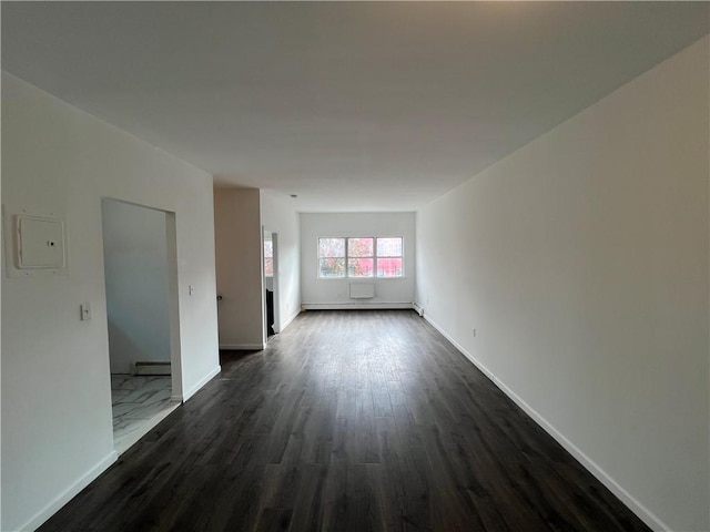 unfurnished room with a baseboard radiator, dark wood-type flooring, and electric panel