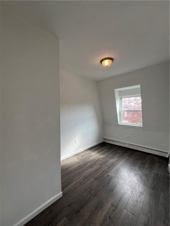 unfurnished room with a baseboard radiator and dark hardwood / wood-style flooring