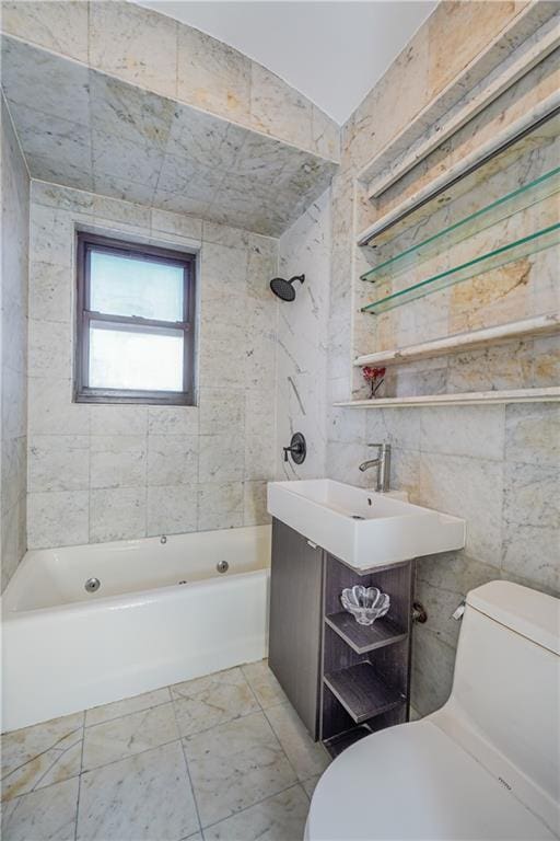 full bathroom with toilet, tile walls, tiled shower / bath, and vanity