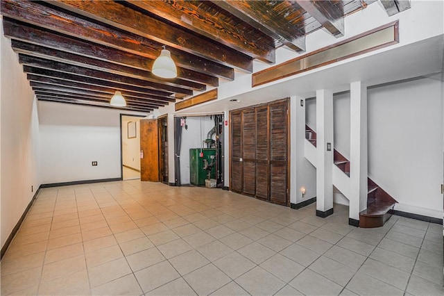 finished below grade area featuring tile patterned floors, stairway, and baseboards