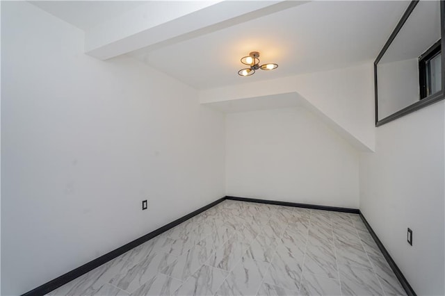 additional living space with marble finish floor and baseboards