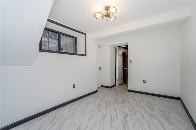 unfurnished room featuring baseboards and marble finish floor