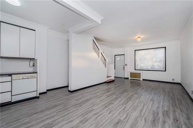 interior space with stairway, wood finished floors, baseboards, and ornamental molding