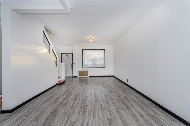 empty room with light wood-type flooring and ornamental molding