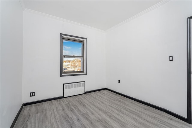 unfurnished room featuring light wood-style floors, baseboards, radiator, and crown molding