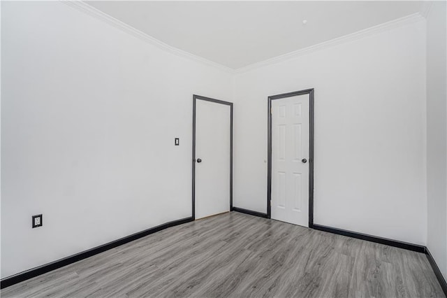 unfurnished bedroom with light wood-style flooring, baseboards, and ornamental molding