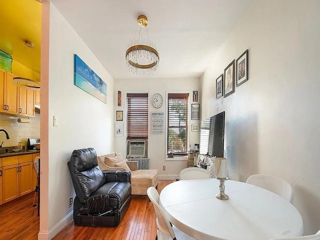 dining space featuring hardwood / wood-style floors, cooling unit, and sink