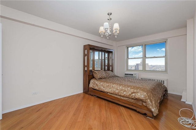 bedroom featuring a notable chandelier, light wood-style flooring, radiator, and baseboards