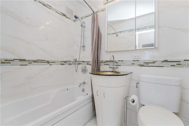 bathroom with shower / washtub combination, toilet, vanity, marble finish floor, and tile walls