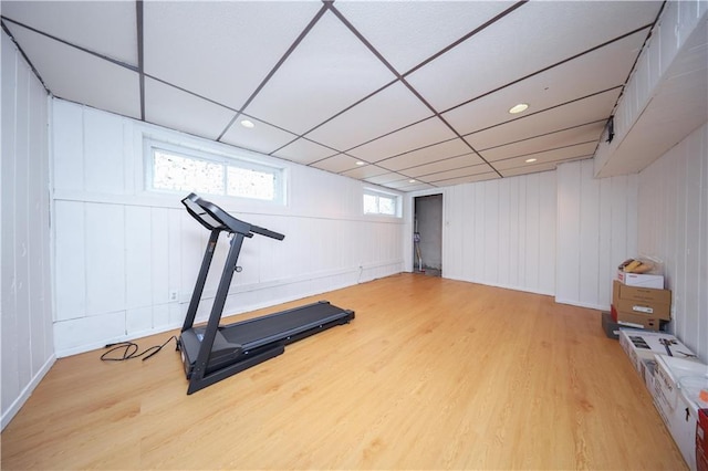 workout room featuring wooden walls and light hardwood / wood-style flooring