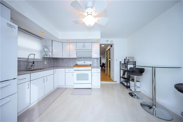 kitchen with white cabinetry, sink, ceiling fan, backsplash, and white appliances