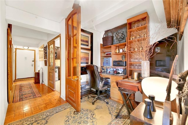 office space featuring beamed ceiling, light parquet floors, and built in desk