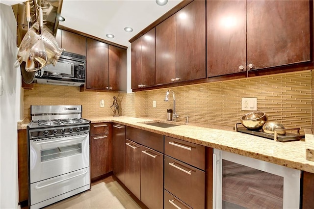 kitchen featuring sink, wine cooler, decorative backsplash, range with gas stovetop, and light stone counters