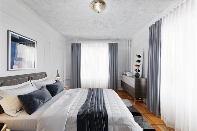 bedroom with parquet floors and a textured ceiling