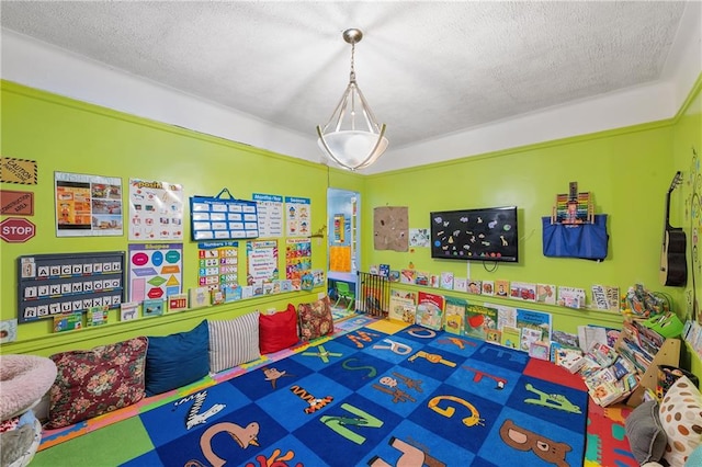 recreation room with a textured ceiling