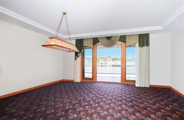 empty room with crown molding, carpet, and a water view