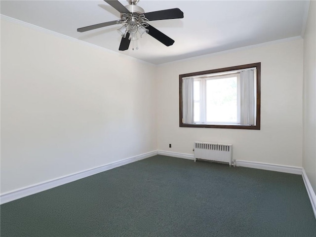 spare room with dark carpet, radiator, ornamental molding, and ceiling fan