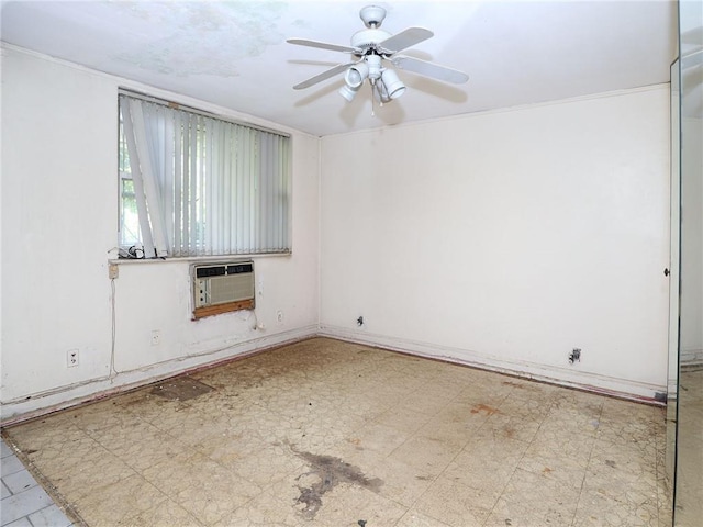 spare room with an AC wall unit and ceiling fan