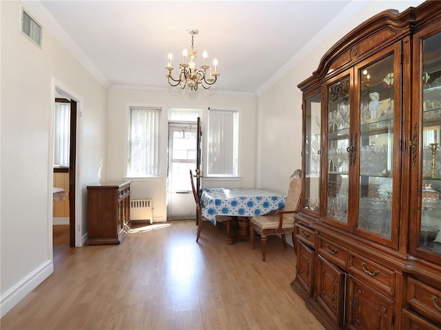 unfurnished dining area featuring radiator, an inviting chandelier, ornamental molding, and light wood-type flooring