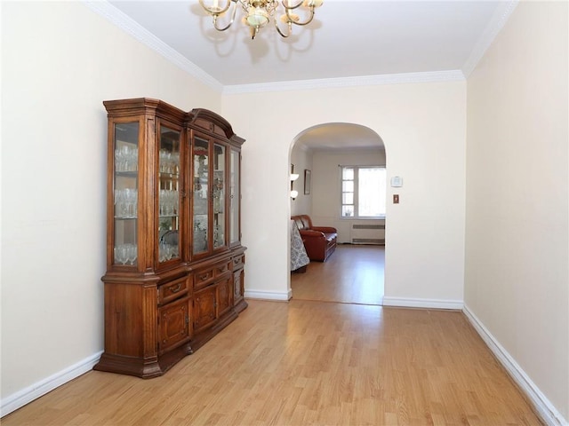 interior space with an inviting chandelier, light hardwood / wood-style flooring, radiator, and crown molding