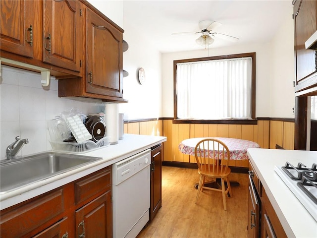 kitchen with tasteful backsplash, white appliances, ceiling fan, sink, and light hardwood / wood-style flooring