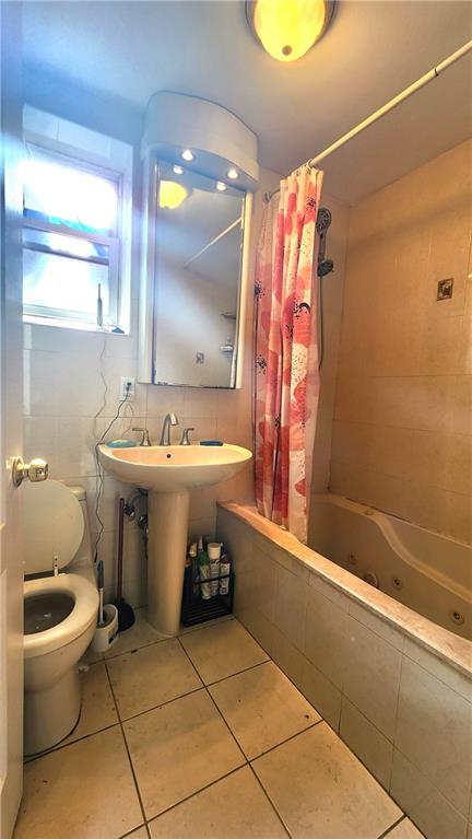 bathroom with tile patterned flooring, toilet, and shower / bathtub combination with curtain