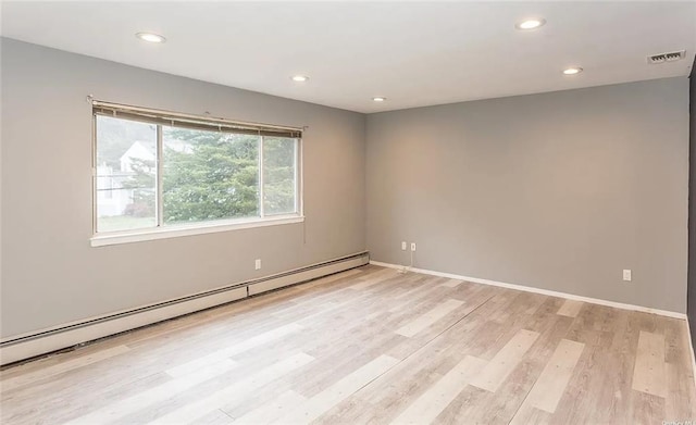 empty room with light wood-type flooring and baseboard heating