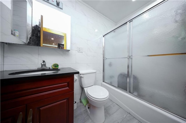 full bathroom with vanity, enclosed tub / shower combo, tile walls, and toilet