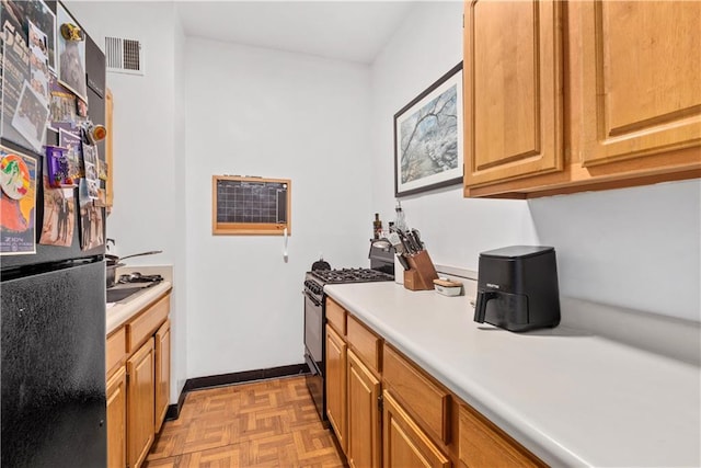 kitchen featuring a wall mounted air conditioner, light parquet floors, and black appliances