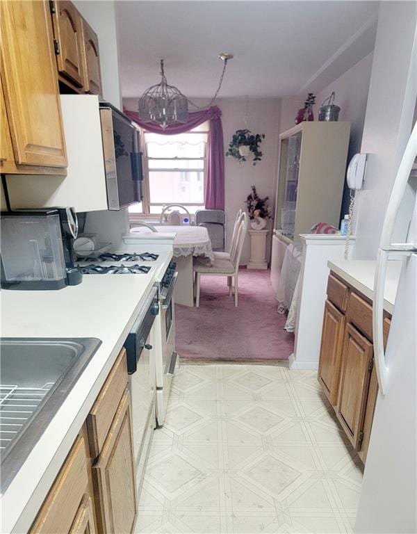 kitchen featuring sink, white appliances, and a notable chandelier