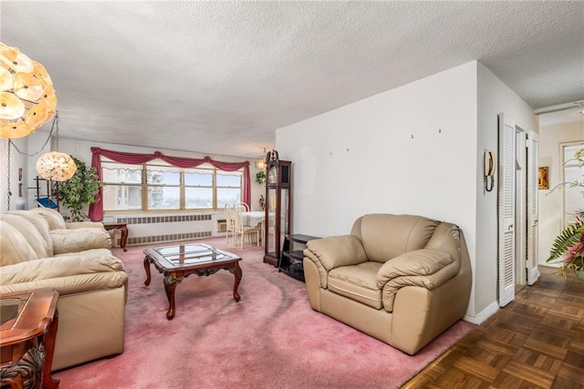 living room featuring radiator, dark parquet floors, and a textured ceiling