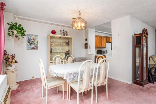 carpeted dining area featuring an AC wall unit, a textured ceiling, radiator heating unit, and an inviting chandelier