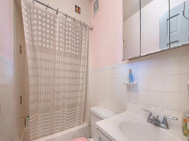 full bathroom featuring vanity, shower / bath combination with curtain, decorative backsplash, toilet, and tile walls