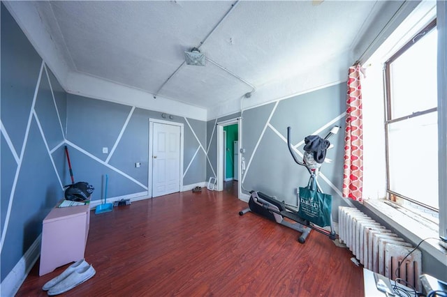 workout area featuring radiator and hardwood / wood-style floors