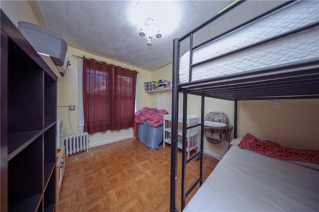 bedroom featuring radiator and parquet flooring