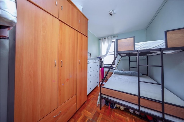 bedroom featuring dark parquet flooring