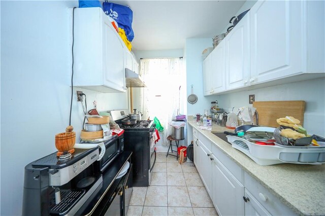 kitchen featuring light tile patterned floors, white cabinets, and stainless steel gas range